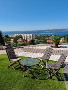 two chairs and a glass table on a lawn at L'Occitane bleu in Sète