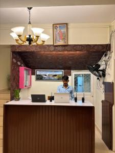 a man sitting at a counter with two laptops at Holiday Beach Resort in Aguada