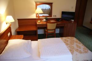 a hotel room with a bed and a desk with a computer at Gościniec Sucholeski in Suchy Las