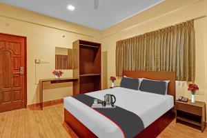 a hotel room with a large bed and a desk at Hotel O Rithanya Manyata Stay inn in Bengaluru