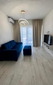 a living room with a blue couch and a tv at Apartments Sea Side in Petrovac na Moru +20 photos