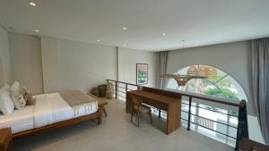 Un dormitorio con una cama y un escritorio y una ventana. en Two Palms Bingin, en Uluwatu 106 fotos más