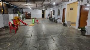 an empty room with chairs and a slide at Nain Guest House in Ujjain