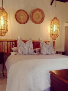 a bedroom with a large white bed with two pillows at Wild Fig Accommodation in Tzaneen