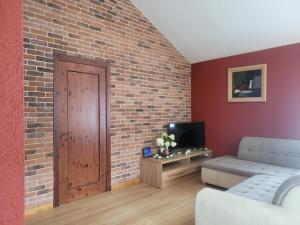 a living room with a brick wall and a door at Cozy Corner in Saulkrasti