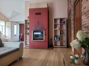 a living room with a red wall with a tv at Cozy Corner in Saulkrasti