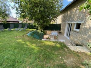 a yard with a stone building and a tree at Maison chaleureuse avec piscine et aire de jeux in Tramery