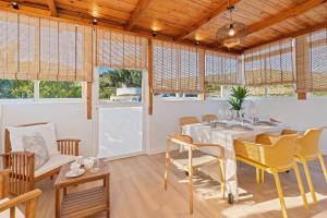 a dining room with a table and chairs and windows at Comeback LA CASA OCULTA DE LA LUNA in Salobreña