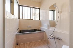 a bathroom with a sink and a shower at Abiko Stay in Osaka Namba in Osaka