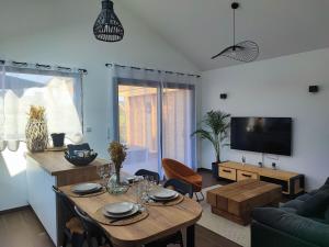 a living room with a table and a tv at Les Suites du Littoral in Plouézec