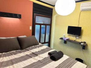 a bedroom with a bed with a television and a window at Hotel粋 in Hakodate