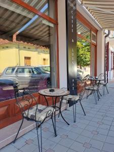 una fila di tavoli e sedie su un patio di Hostel Tema Nova Centar a Čačak