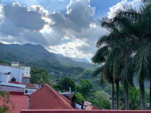 a view of a city with palm trees and mountains at Céntrica habitación 2 camas queen - Gran Nehtolli #7 - Sin Estacionamiento in Xilitla