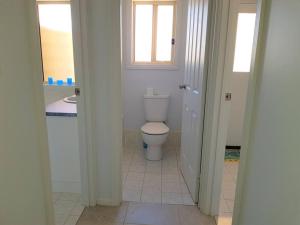 a white bathroom with a toilet and a sink at Avventura in Wallaroo +8 photos