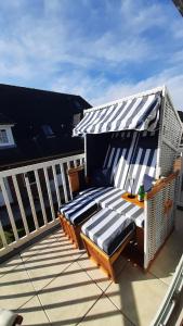 a deck with two lounge chairs and an umbrella at Ferienwohnung Fernsicht nach Büsum in Westerdeichstrich