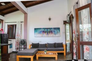 a living room with a couch and a table at Villa A & A Hikkaduwa in Hikkaduwa