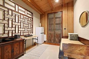 a room with a refrigerator and a table with a bench at Birch Suite - Rocky Creek Art Garden in Olinda