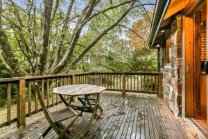 a wooden deck with a picnic table on it at Beech Suite - Rocky Creek Art Garden in Olinda