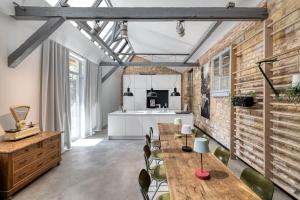 a kitchen with brick walls and wooden tables and chairs at Baumann & Müller in Walsheim