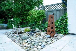 a garden with a sign in a pile of rocks at Ferienhaus Kogge Behnken in Schönhagen