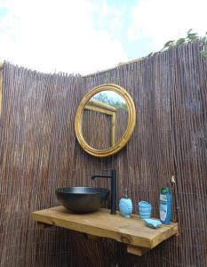Un lavabo de baño y un espejo en una valla en Studio with pool garden and open roof bathroom, en Lajares