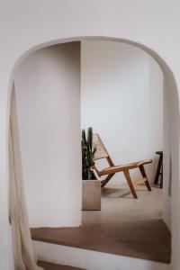 a white room with a chair and a plant at L’Edicola Votiva in Casarano