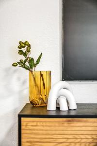 墨尔本Large 3 Bed Art Deco Apartment in Camberwell的黄花瓶坐在桌子上,与植物一起