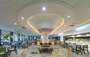 a restaurant with tables and chairs and a large ceiling at Marhaba Royal Salem - Family Only in Sousse