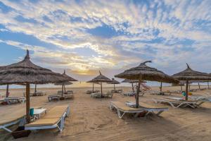 a group of beach chairs and umbrellas on a beach at Marhaba Royal Salem - Family Only in Sousse