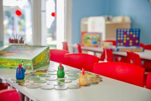 a classroom with red chairs and a table with toys on it at Marhaba Royal Salem - Family Only in Sousse