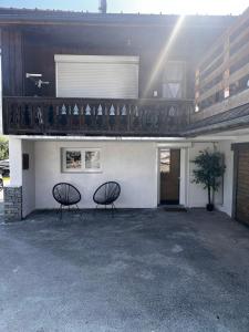 two chairs sitting in front of a building at Appartement les Sapineaux in Courchevel