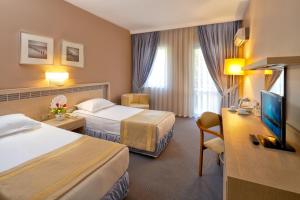 um quarto de hotel com duas camas e uma televisão de ecrã plano em Pam Thermal Hotel Clinic & Spa em Pamukkale