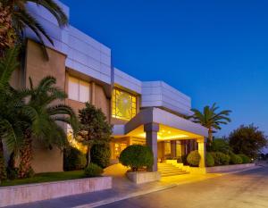 a large building with palm trees in front of it at Pam Thermal Hotel Clinic & Spa in Pamukkale