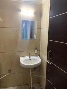 bagno con lavandino e specchio a parete di Hotel BCP Suites a Bangalore Altre 33 foto