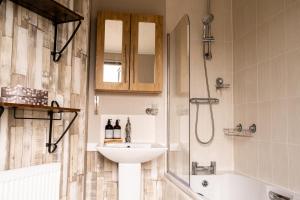 a bathroom with a sink and a shower and a tub at Luxury Lodge in Forfar
