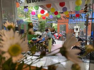 a woman standing in a room with two dogs at Bonjour Hostel in Hue