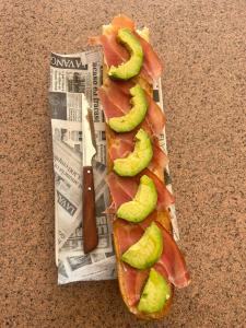 a sandwich with pickles on a newspaper with a knife at Pensión Xiquena in Fiñana