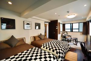 Un dormitorio con dos camas y un escritorio y una mesa. en 島内小宿, en Osaka