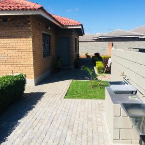 a brick house with a driveway and a door at Kwakwethu in Bulawayo +27 photos