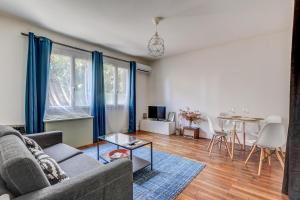 uma sala de estar com um sofá e uma mesa em La maison bleue 65 M2 , cœur des Minimes à Toulouse em Toulouse