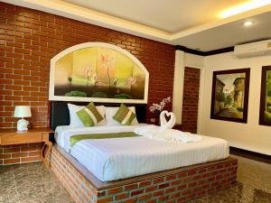 ein Schlafzimmer mit einem großen Bett in einer Ziegelwand in der Unterkunft Fullmoon Beachresort Krabi in Ao Nang Beach