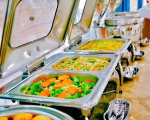 a buffet with three trays of food on a table at Tuyet Son Hotel (TS Ocean Hotel) in Da Nang