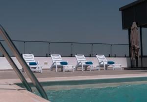 a group of chairs sitting next to a swimming pool at Best Western Plus Jeddah Hotel Madinah Road in Jeddah