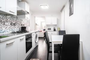 a kitchen with white cabinets and a table with chairs at Spinola Palace Apartment in Genoa