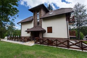 una casa con una valla de madera en el patio en Apartment Gledovic, en Zlatibor