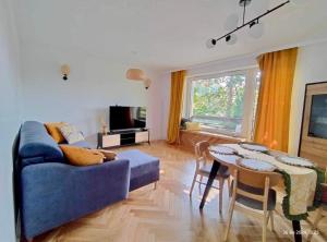 a living room with a blue couch and a table at Saltwater Apartment Gdynia in Gdynia