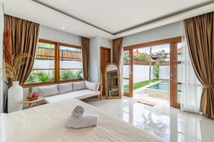 a bedroom with a large bed and a couch at Sofia 1- Luxury Retreat - Brand New 2BR Villa with Private Pool in Canggu +2 photos