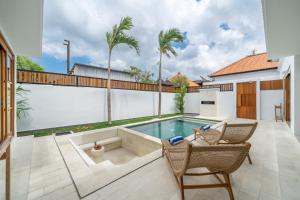 a backyard with a swimming pool and two chairs at Sofia 1- Luxury Retreat - Brand New 2BR Villa with Private Pool in Canggu