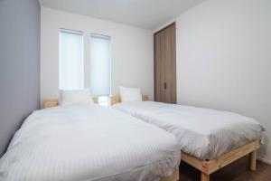 A bed or beds in a room at 新屋 札幌市中心薄野車程5分鐘 挑高設計客廳 可停車1台 高速Wi Fi 地鐵徒步5分 一站到薄野