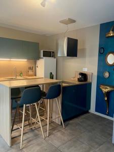 a kitchen with blue cabinets and a table and chairs at Chez Prunette in Belleville-sur-Meuse +1 photo